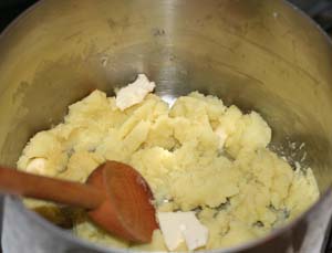adding butter to the potatoes